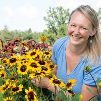 Anna Pröbstle inmitten einer Blumenwiese.