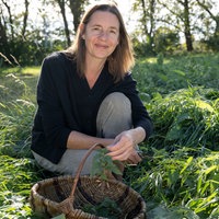 Christine Huber mit einem Korb Kräuter.