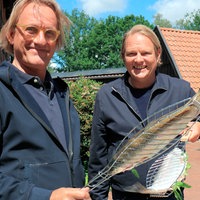 Frank Buchholz (l) und Björn Freitag bereiten für das Jubiläums-Dinner regionale Lachsforellen auf dem Grill zu.
