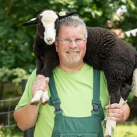 Michael Stücke mit einem Schaf auf den Schultern. 