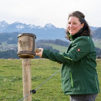 Theresa Tischner auf der Weide mit Bergpanorama im Hintergrund.