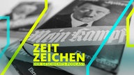 Mehrere Bücher von Adolf Hitlers "Mein Kampf" liegen auf einem Tisch.