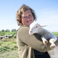 Anja Wolff mit einem Lamm auf dem Arm.