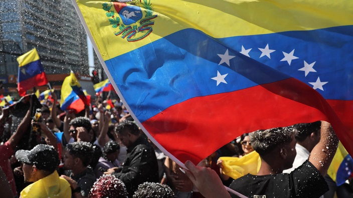 Venezolaner wehen mit ihrer Nationalflagge