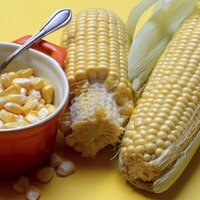 Frische Maiskörner in Topf und Maiskolben
