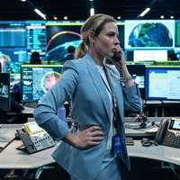 Szene aus dem Film "A House of Dynamite": Rebecca Ferguson als Captain Olivia Walker steht telefonierend in einem Kontrollraum, umgeben von Bildschirmen. Sie sieht ernst aus und hat eine Hand an die Hüfte gestemmt.