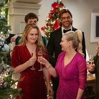 Eine Szene des Films "A Merry Little Ex-Mas": Die Familie steht festlich gekleidet im weihnachtlichen geschmückten Wohnzimmer und stößt mit Sekt an. 