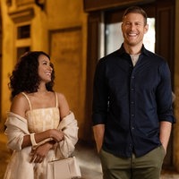 Eine Szene des Films "Love in the Villa": Julie (Kat Graham) und Charlie (Tom Hopper) spazieren abends durch die Straßen von Verona. Julie schaut Charlie an, beide lächeln.