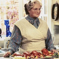 Eine Szene aus dem Film "Mrs. Doubtfire": Robin Williams steht als ältere Dame Mrs Doubtfire verkleidet in der Küche. 