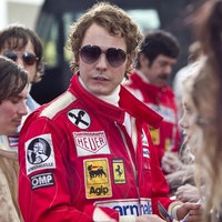 Eine Szene des Films "Rush – Alles für den Sieg": Der Schauspieler Daniel Brühl als Niki Lauda Autogramme gebend in roter Rennfahrer-Montur