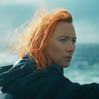 Eine Szene des Films "The Outrun": Saoirse Ronan mit roten Haaren als Rona vor einem stürmischen Meer