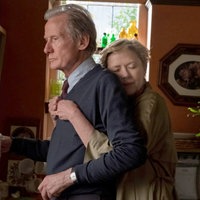 Eine Szene aus dem Film "Wer wir sind und wer wir waren": Grace (Annette Bening) und ihr Ehemann Edward (Bill Nighy) in der Küche. Er blickt ernst geradeaus in die Ferne, sie hat ihre Arme von hinten um ihn gelegt und schmiegt sich an seinen Rücken.