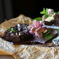 Brownies garniert mit Salzflocken, einige Stücke sind auf einer Servierplatte angerichtet, die restlichen Stücke liegen noch daneben auf Backpapier.
