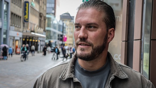 Fillialleiter Matthias Schneider steht vor seiner Parfümerie in Dortmund