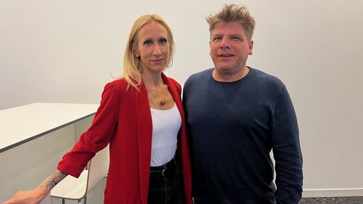 Eine Frau und ein Mann lächeln in die Kamera