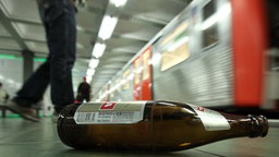 Eine Bierflasche liegt am Bahnsteig