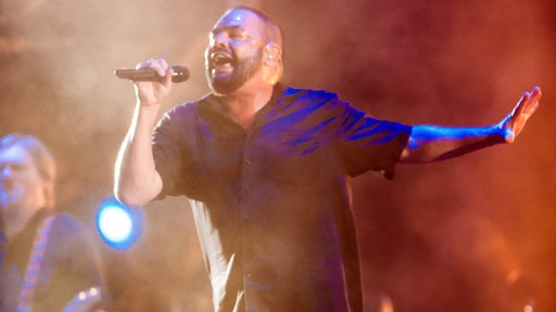 Alphaville singt in ein Mikrofon