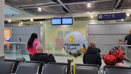 In der Ankunftshalle des Düsseldorfer Flughafens warten Angehörige der Menschen, die mit der ersten Maschine seit dem Wochenende aus Dubai kommen.