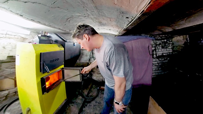 Andreas Schreiter steht in seinem Haus vor der Zentralheizung, in der heimische Kohle brenntAndreas Schreiter steht in seinem Haus vor der Zentralheizung, in der heimische Kohle brennt