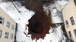 Erdkrater in verschneiter Wiese