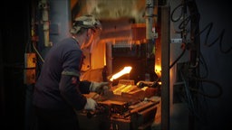 Arbeiter schmiedet Metallstück