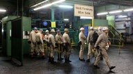 Bergleute warten in Kamp-Lintfort am Förderkorb von Bergwerk West auf die Einfahrt.
