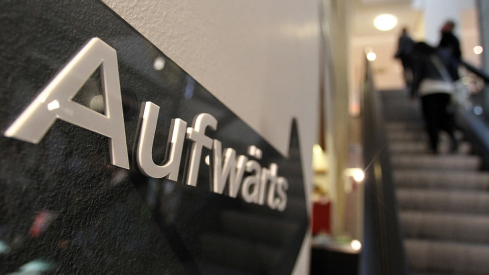 "Aufwärts" ist auf einem Schild neben einer Rolltreppe in einem Kaufhaus zu lesen