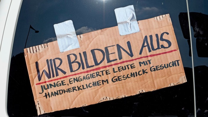Pappschild an einer Autoscheibe mit der Aufschrift: Wir Bilden Aus 
