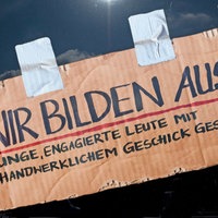 Pappschild an einer Autoscheibe mit der Aufschrift: Wir Bilden Aus 