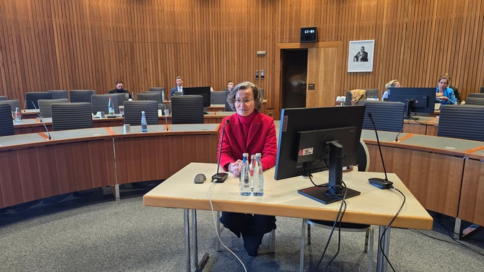 Ina scharrenbach sitzt auf einem Stuhl an einem Tisch 