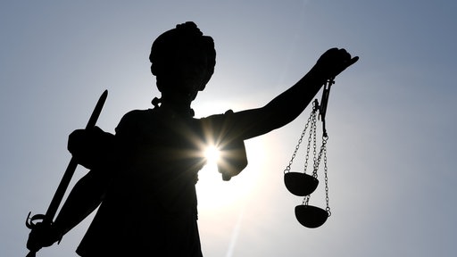Eine Justitia-Statue im Gegenlicht 
