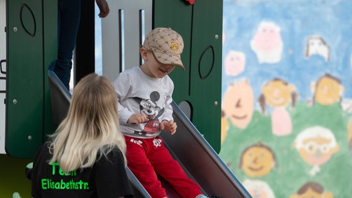 Kinder rutschen auf einer Rutsche