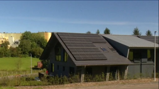 Ein dunkles Haus mit Solarpanelen auf dem Dach