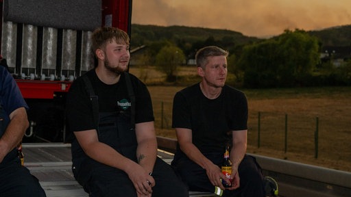 Mitglieder der Freiwilligen Feuerwehr machen kurz Pause beim Waldbrand im Hürtgenwald