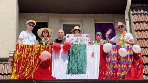 Diese Carnival-Fans haben den besten Blick vom Balkon auf den Umzug.