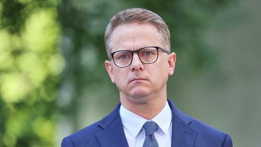 Carsten Linnemann bei der Vorstellung zur Kabinettsumbildung, vor grünem Hintergrund