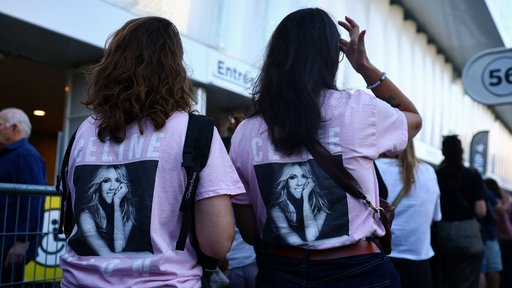 Zwei Fans mit Celine Dion T-shirts stehen in eine Warteschlange 
