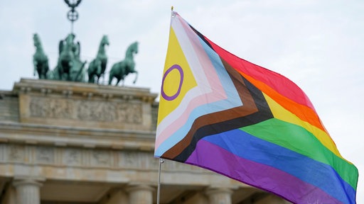 Eine Fahne der LGBTQ+-Community weht im Wind