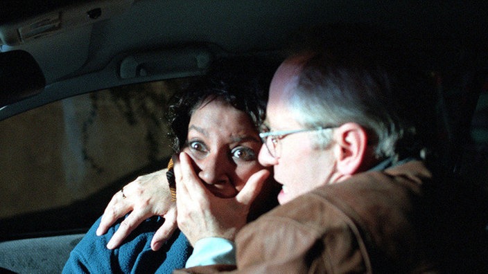 Abends fährt Hans (Joachim Hermann Luger) Mary (Liz Baffoe) zu ihrer Freundin, bei der sie endlich John wiedersehen soll. Doch die beiden müssen mit ansehen, wie John von zwei Polizisten abgeführt wird.