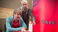 Adi und Lotti reden im Café George mit jemandem