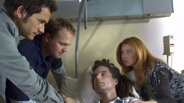 Alex (Joris Gratwohl, links), Klaus (Moritz A. Sachs, 2.v.l.) und Iffi (Rebecca Siemoneit-Barum) sind in großer Sorge um Momo (Moritz Zielke): Der liegt nach seinem Schlaganfall im Krankenhaus.