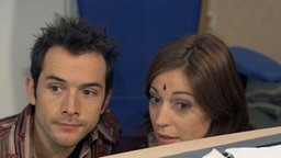 Alex und Marion verstecken sich unter dem Tisch