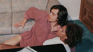 Als sich Mary (Liz Baffoe) und Vasily (Hermes Hodolides) nahe kommen, hören sie verdächtige Geräusche an der Wohnungstür.