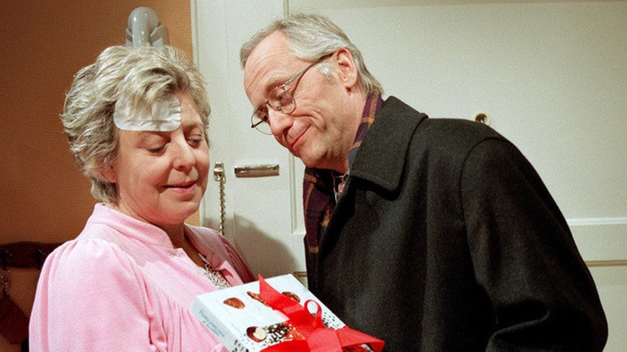 Alte Fürsorge rostet nicht: Hans (Joachim Hermann Luger) macht einen Krankenbesuch bei Helga (Marie-Luise-Marjan), die noch immer an den Folgen des Überfalls leidet.