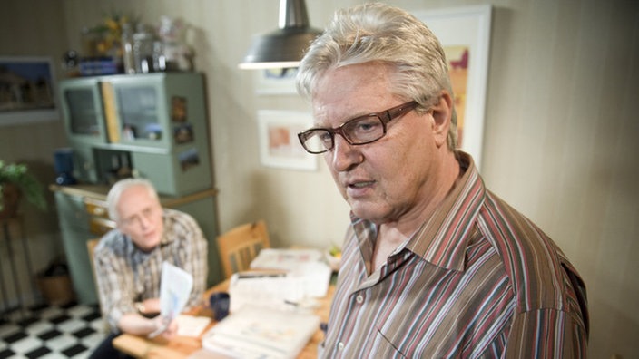 Andy sitzt mit Hans grübelnd in seiner Küche