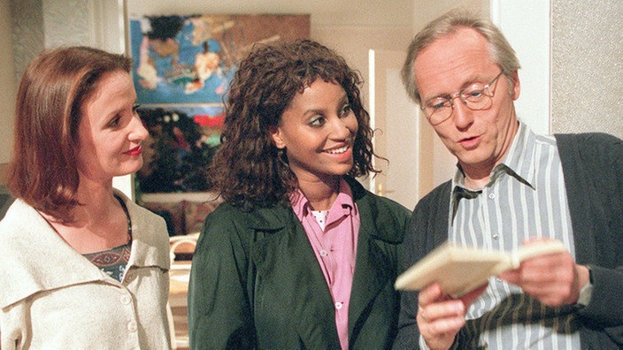 Anna (Irene Fischer, links) und Hans (Joachim Hermann Luger) überraschen Mary (Liz Baffoe) mit einem Griechisch-Wörterbuch