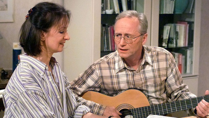 Anna (Irene Fischer) und Hans (Joachim Hermann Luger) durchforsten die Stellenanzeigen nach dem Zufallsprinzip. Sobald Hans das Gitarrenspiel stoppt, tippt Anna blind auf ein Stellenangebot - und dort soll sich Hans dann bewerben.