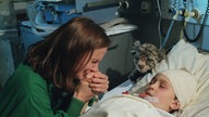 Anna sitzt an Toms Krankenbett