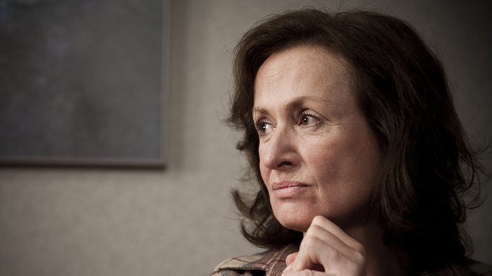 Anna sitzt niedergeschlagen im Wohnzimmer