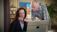 Anna und Hans gucken etwas auf dem Laptop an